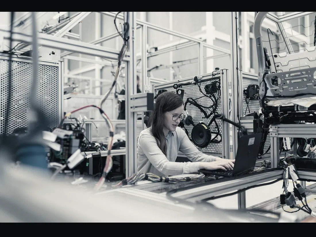 An engineer working at a production cell, checking an assembly against a terminal.